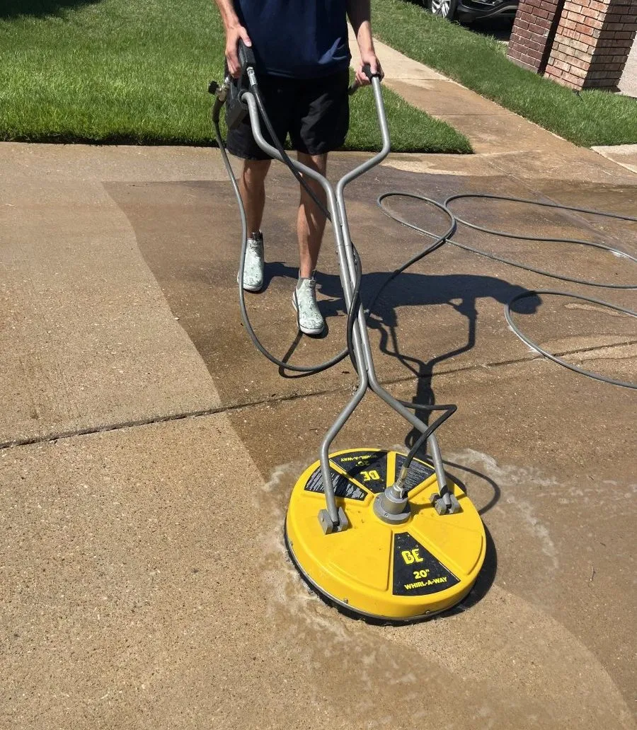 A freshly power-washed concrete driveway — the clean line against the dirty section
